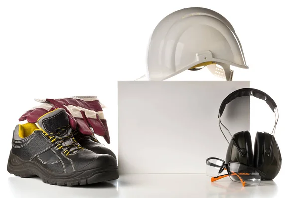 Work safety and protection equipment - protective shoes, safety glasses, gloves and hearing protection over white background with blank card for copy