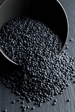 Siyah organik beluga mercimek seçici odak siyah taş zemin üzerine siyah kase yığını