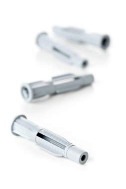 Yeni, kullanılmamış, gri plastik dübel closeup beyaz arka plan üzerinde - seçici odak cıvata