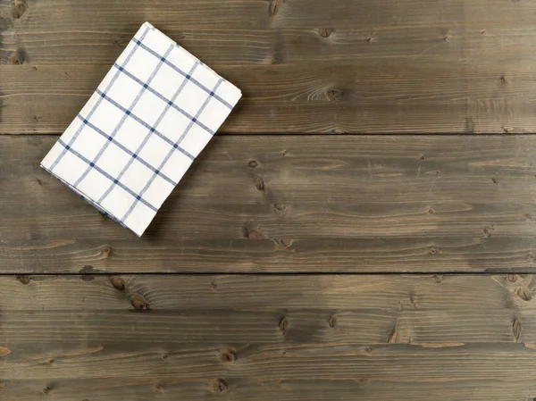 蓝色和白色格子抹布在棕色质朴的木板桌平的顶部看法从上面与复制空间 — 图库照片