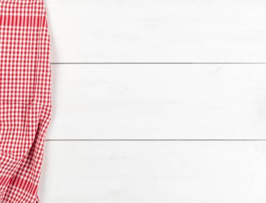Düz beyaz ahşap tahta masada kırmızı kareli bulaşık bezi üstten üstten görünüm kopya alanı ile yatıyordu.