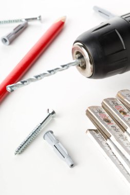 Dübel dübelli vida, kural ve kalem beyaz masaya - ev geliştirme, onarım veya DIY kavramı katlanır elektrikli matkap ile