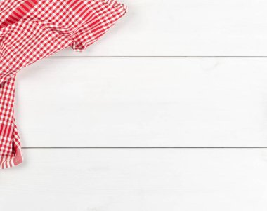 Düz beyaz ahşap tahta masada kırmızı kareli bulaşık bezi üstten üstten görünüm kopya alanı ile yatıyordu.