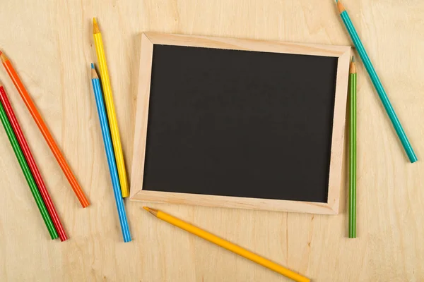Black Empty Blank Chalkboard Colored Pencils Brown Wooden Desk Flat — Stock Photo, Image