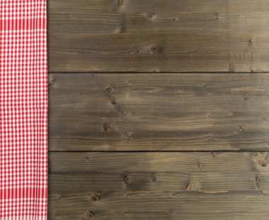 Düz kahverengi rustik ahşap tahta masada kırmızı kareli bulaşık bezi üstten üstten görünüm kopya alanı ile yatıyordu.