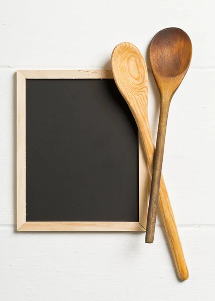 Blank, empty, black chalkboard with wooden cooking spoons flat l — Stock Photo, Image