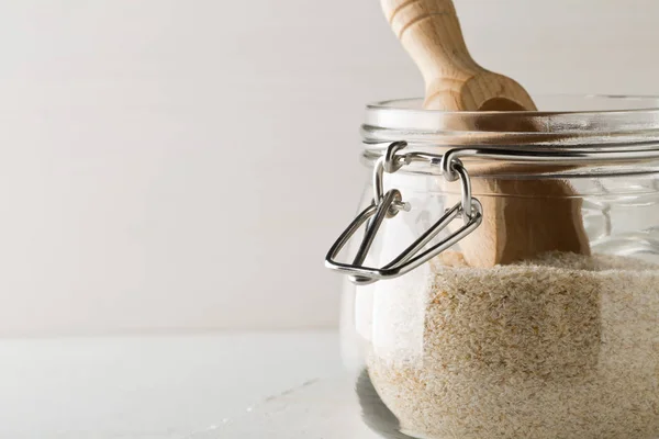 Montón de cáscara de psyllium también llamado isabgol en frasco de vidrio con madera —  Fotos de Stock