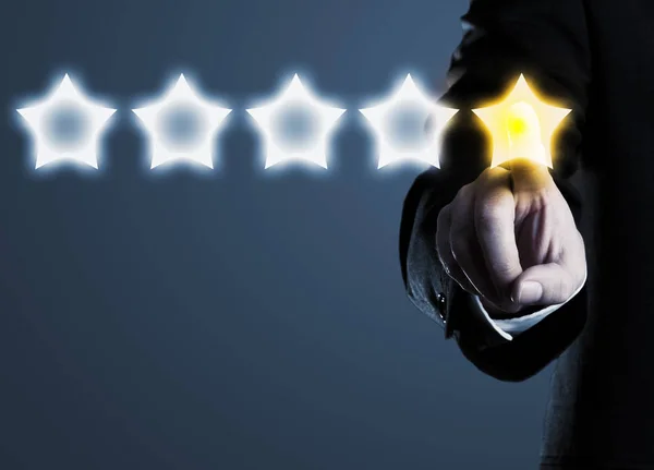 Business man in suit pointing at five star rating stars, selecti