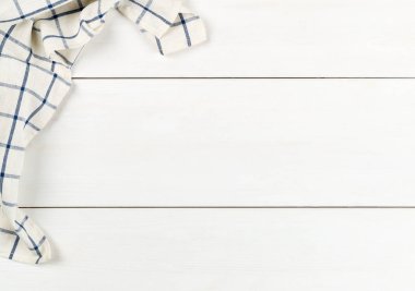 Beyaz ahşap tahta masa üzerinde mavi ve beyaz damalı bulaşık bezi f