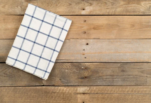 棕色质朴的木板上的蓝色和白色格子抹布 — 图库照片