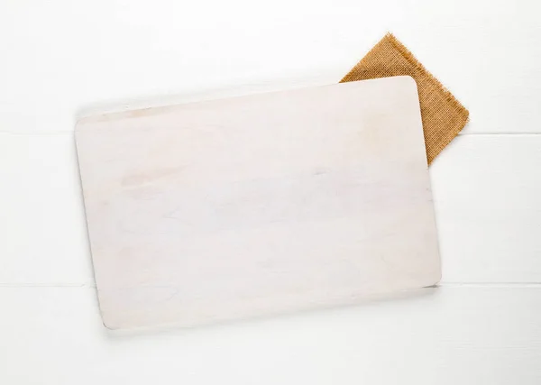 Pusta biała deska do krojenia na białym drewnianym stole tło Top v — Zdjęcie stockowe