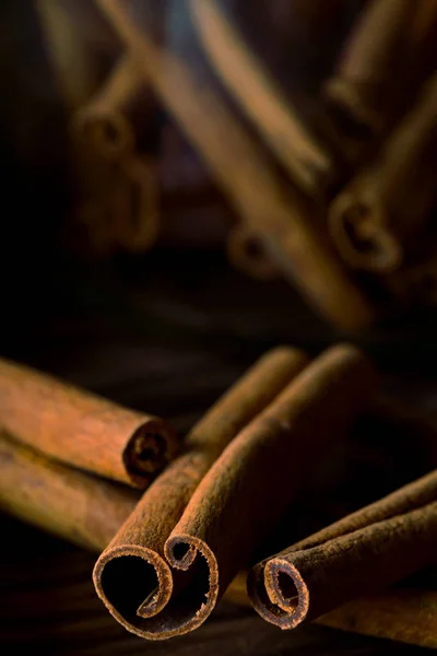 Dried cinnamon sticks on rustic wooden table - selective focus — Stock Photo, Image