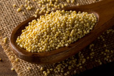 Altın darı yığını, bir glutensiz tahıl tohumu, tahta kaşık