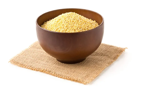 Куча золотого проса, безглютеновое зерно, в деревянной чаше — стоковое фото