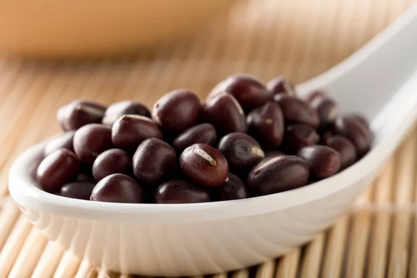 Fagioli adzuki crudi, crudi, secchi (mung rossi) in cucchiaio bianco su b — Foto Stock