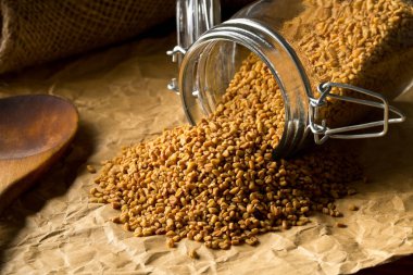 Kurutulmuş, ham çemen tohumu kahverengi ambalaj üzerinde depolama cam kavanoz 