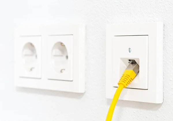 Žlutý síťový kabel v zásuvce ve zdi pro kancelářskou nebo soukromou domácnost l — Stock fotografie