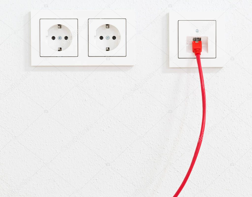 Red network cable in wall outlet for office or private home lan 