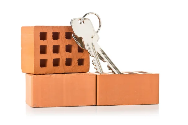 House keys on bricks over white background - home owner, real es — Stock Photo, Image