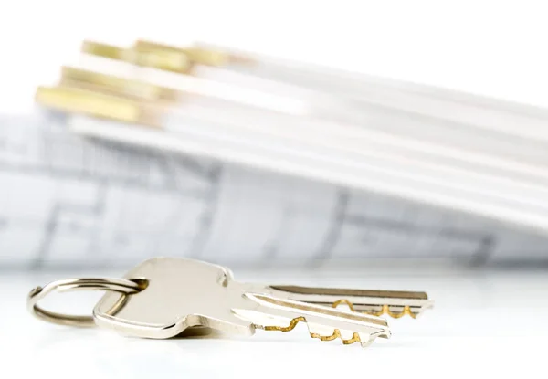 House keys in front of house architectural blueprint and folding — Stock Photo, Image