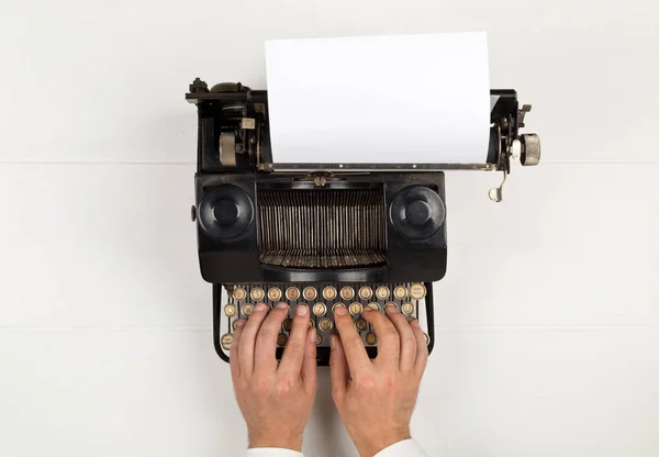 Hombre escribiendo en la máquina de escribir retro vintage sobre fondo de mesa blanco —  Fotos de Stock