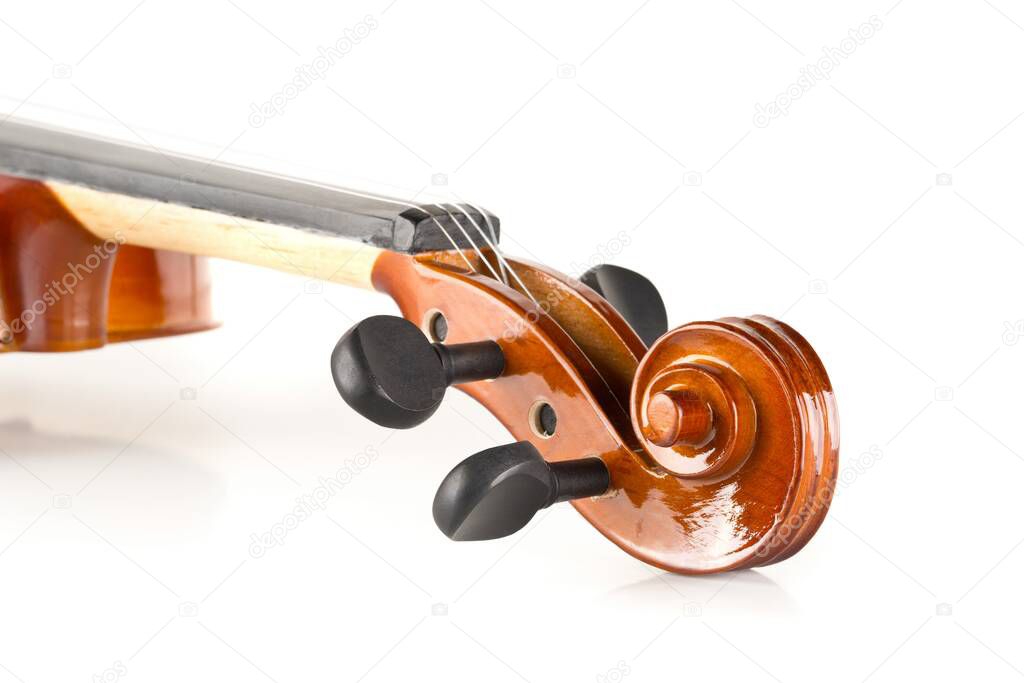 Close up macro of scroll on brown wooden fiddle or violin, classic musical instrument, over white background, selective focus