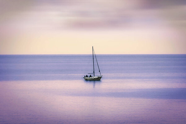Лодка со своими моряками, окруженная спокойным морем и цветами неизбежного заката
.