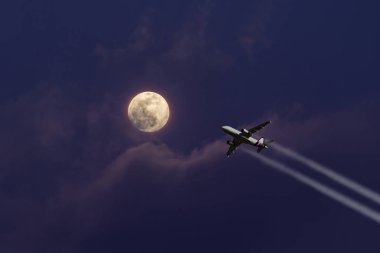 Güzel bir ay ışığı doğru uçan bir uçak