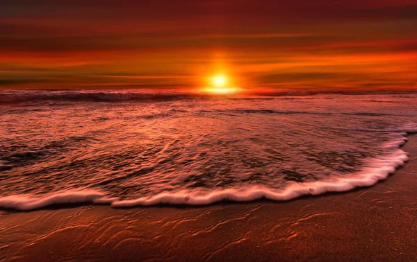 Sun at sunset on a mediterranean beach — Stock Photo, Image