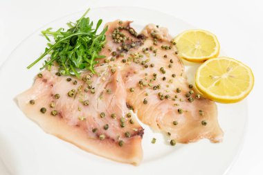 Carpaccio di pesce spada fresco Mediterraneo con peperone verde, erba cipollina e qualche goccia di succo di limone