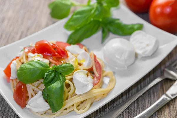 Спагетті зі свіжими помідорами, базиліком та моцарелою . — стокове фото