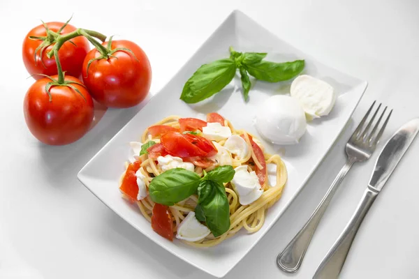 Spaghetti mit frischen Tomaten, Basilikum, Mozzarella und etwas Ogan Stockbild