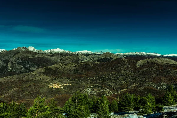 Topo Montanha Nevado Dia Ensolarado Com Cidade — Fotografia de Stock