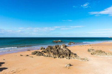 kayalıklar arasında kayalar ve kum ile plaj görünümü