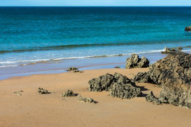 kayalıklar arasında kayalar ve kum ile plaj görünümü