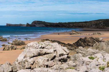 kayalıklar arasında kayalar ve kum ile plaj görünümü