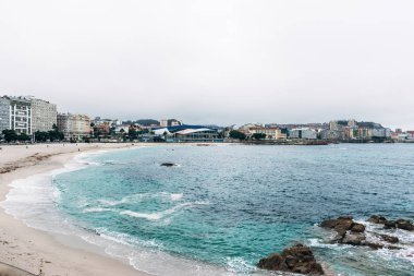 La Coruna, İspanya - 14 Ağustos 2019: Arka planda futbol stadyumu bulunan Riazor plajının panoramik manzarası