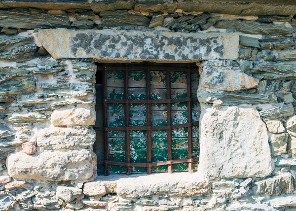 Zamknięte okno w kamiennej ścianie z żelaznymi balustradami w średniowiecznej pustelni — Zdjęcie stockowe