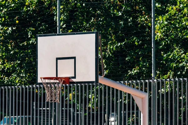 basketball board and basket with net from one side in city park