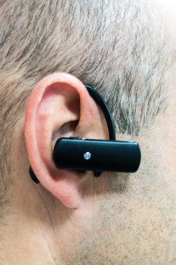 Kablosuz bluetooth kulaklık. Kafkasyalı yetişkin bir adamın kulaklığında.