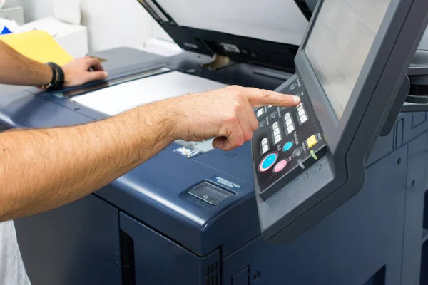 Mão masculina adulta branca no painel de controle de uma fotocopiadora — Fotografia de Stock