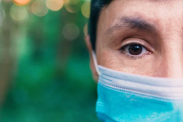 a half face of middle aged woman with face mask