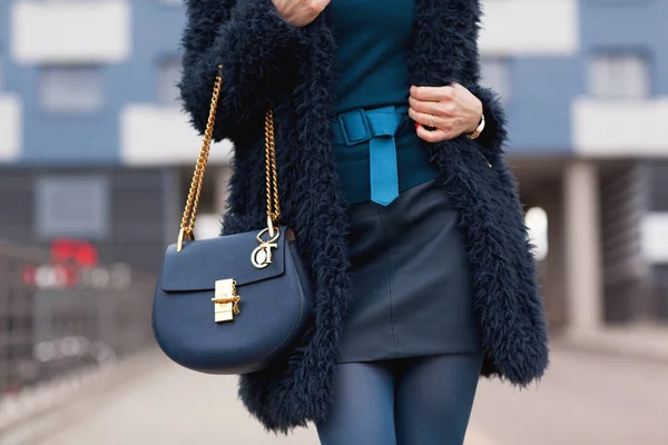 明亮的风格 穿着蓝色毛皮大衣的年轻女孩 手里带着手提包 — 图库照片