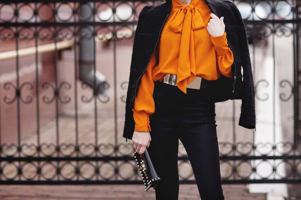 办公室 明亮的风格 女青年 商务型 黑夹克 黑色手袋 太阳镜 橙色上衣 — 图库照片