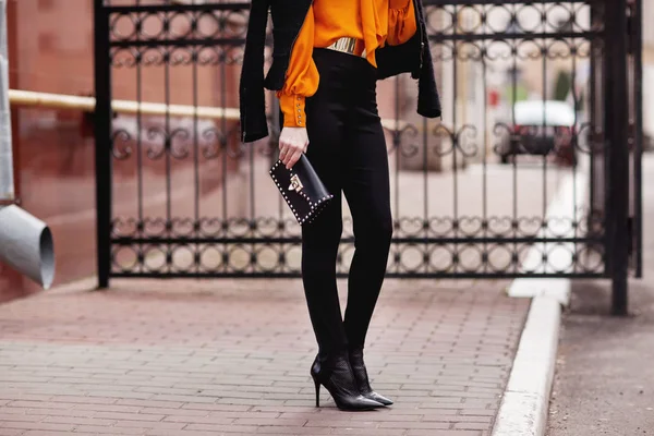 办公室 明亮的风格 女青年 商务型 黑夹克 黑色手袋 太阳镜 橙色上衣 — 图库照片