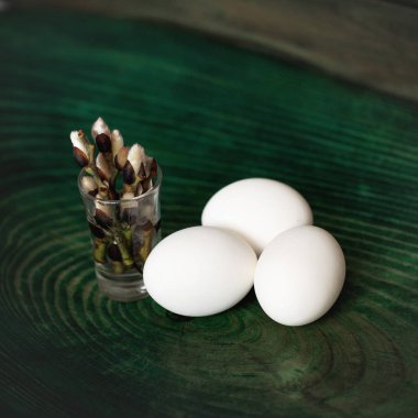 Paskalya yumurtaları ve Söğüt dalları ahşap yeşil arka plan üzerinde. Yukarıdan görüntülemek.