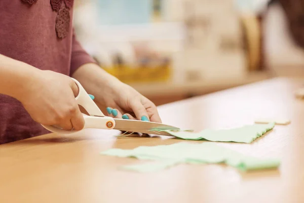 Costurera en el trabajo. Dressmaker corta tela para coser vestidos. Vista lateral — Foto de Stock