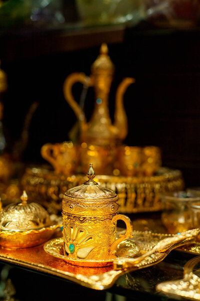 Arabian cup and teapot of gold on the eastern market. Oriental tea