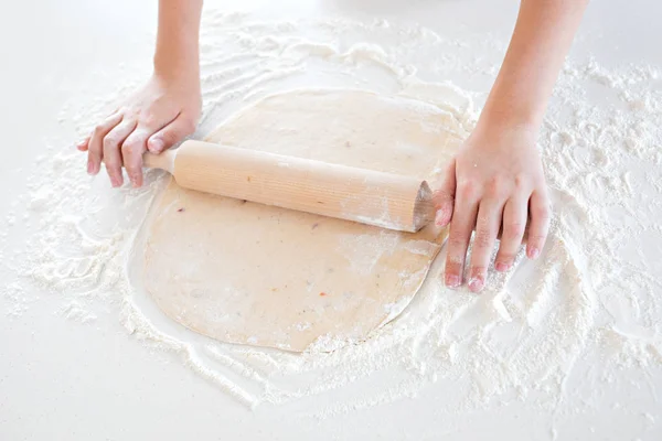 Vista superior de un niño haciendo masa de pizza en una mesa ligera — Foto de Stock