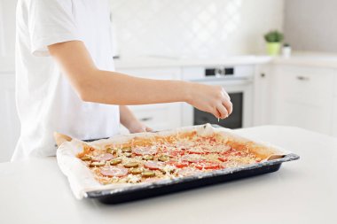 Pişirme konsepti - pizzaya elle rendelenmiş peynir ekleyerek pişirin